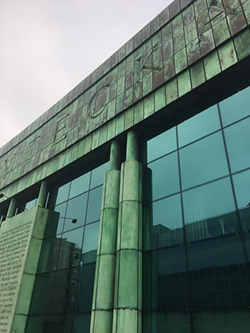 fasada zielonego budynku z szybami i napisami