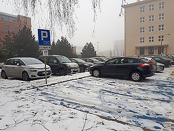zaśnieżony parkinng z dwoma oznaczonymi miejscami do parkowania dla osób z niepełnosprawnościami
