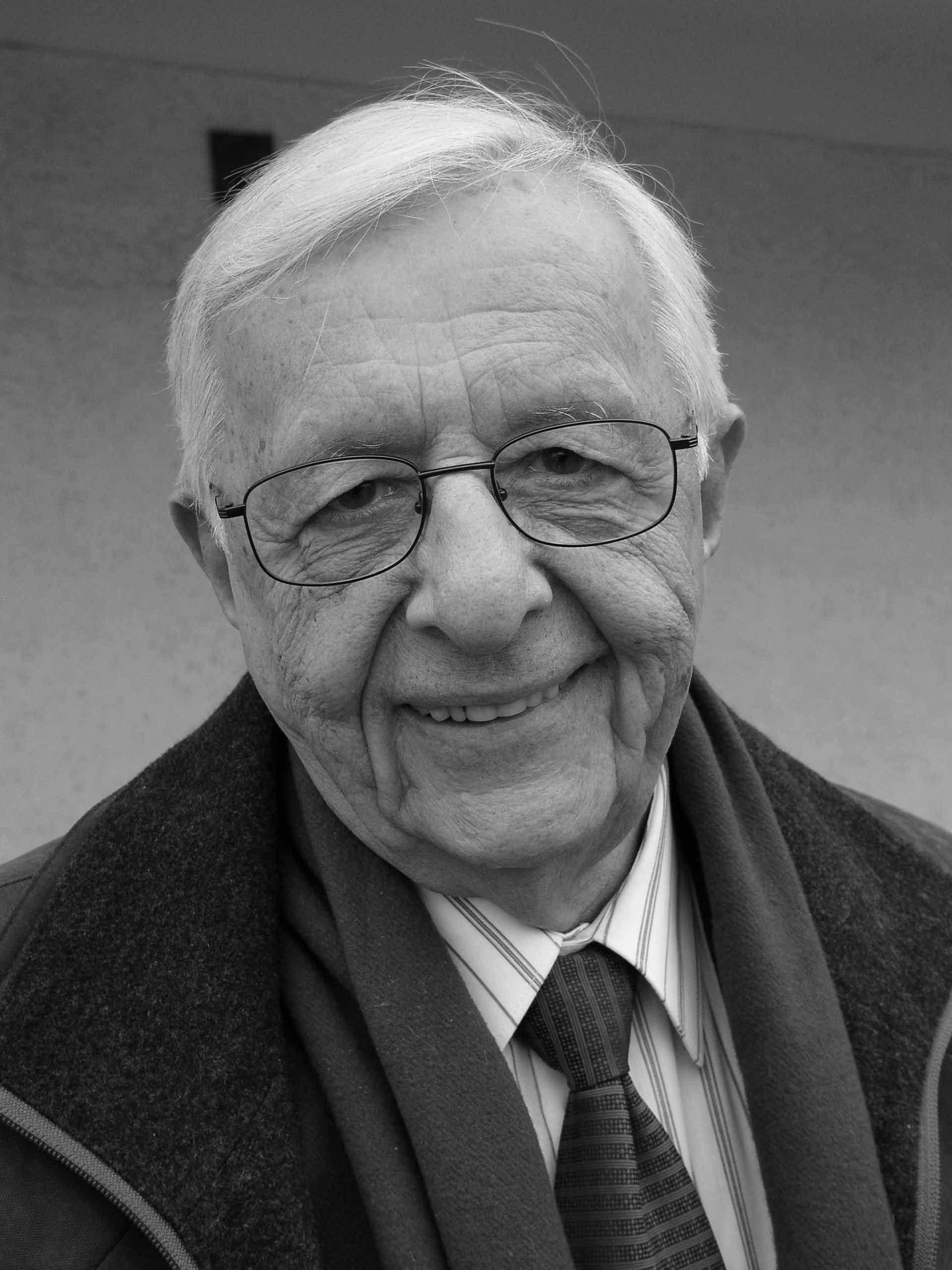 Prof. Juchnowicz. Czarno-białe zdjęcie starszego, uśmiechniętego mężczyzny w okularach