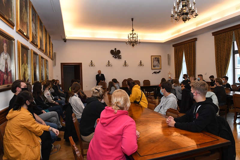 Na zdjęciu młodzi mężczyźni i kobiety siedzą przy stołach w Sali Senackiej PK i z uwagą słuchają osoby mówiącej. Jest nią rektor PK prof. Andrzej Białkiewicz, który stoi przy stole prezydialnym.