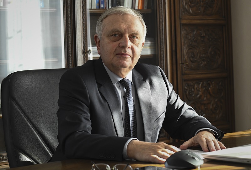 Na zdjęciu rektor Politechniki Krakowskiej profesor Andrzej Białkiewicz siedzący przy biurku w swoim gabinecie