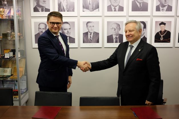 Dr inż. Michał Kwiecień i prof. Jerzy Sładek ściskają dłonie po podpisaniu porozumienia