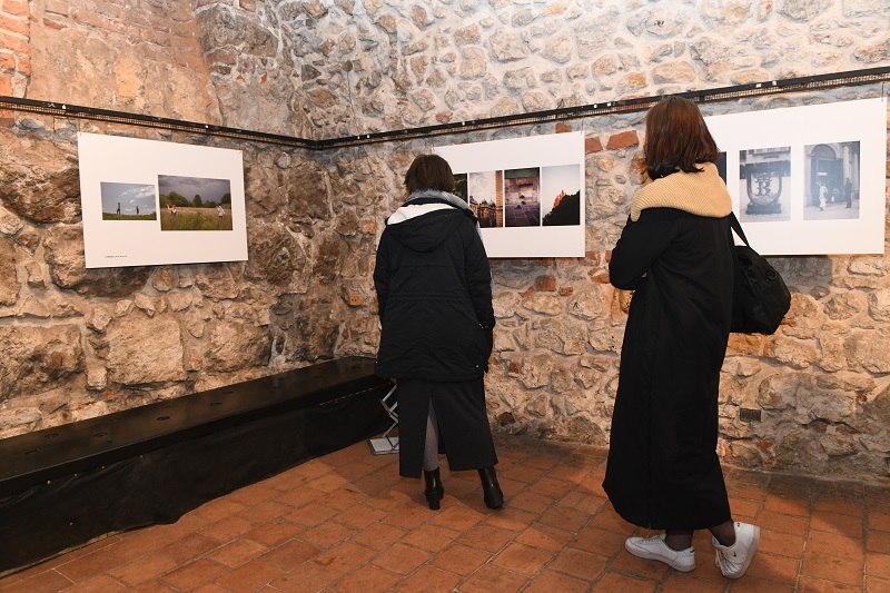 Dwie osoby oglądają zdjęcia prezentowane na wystawie
