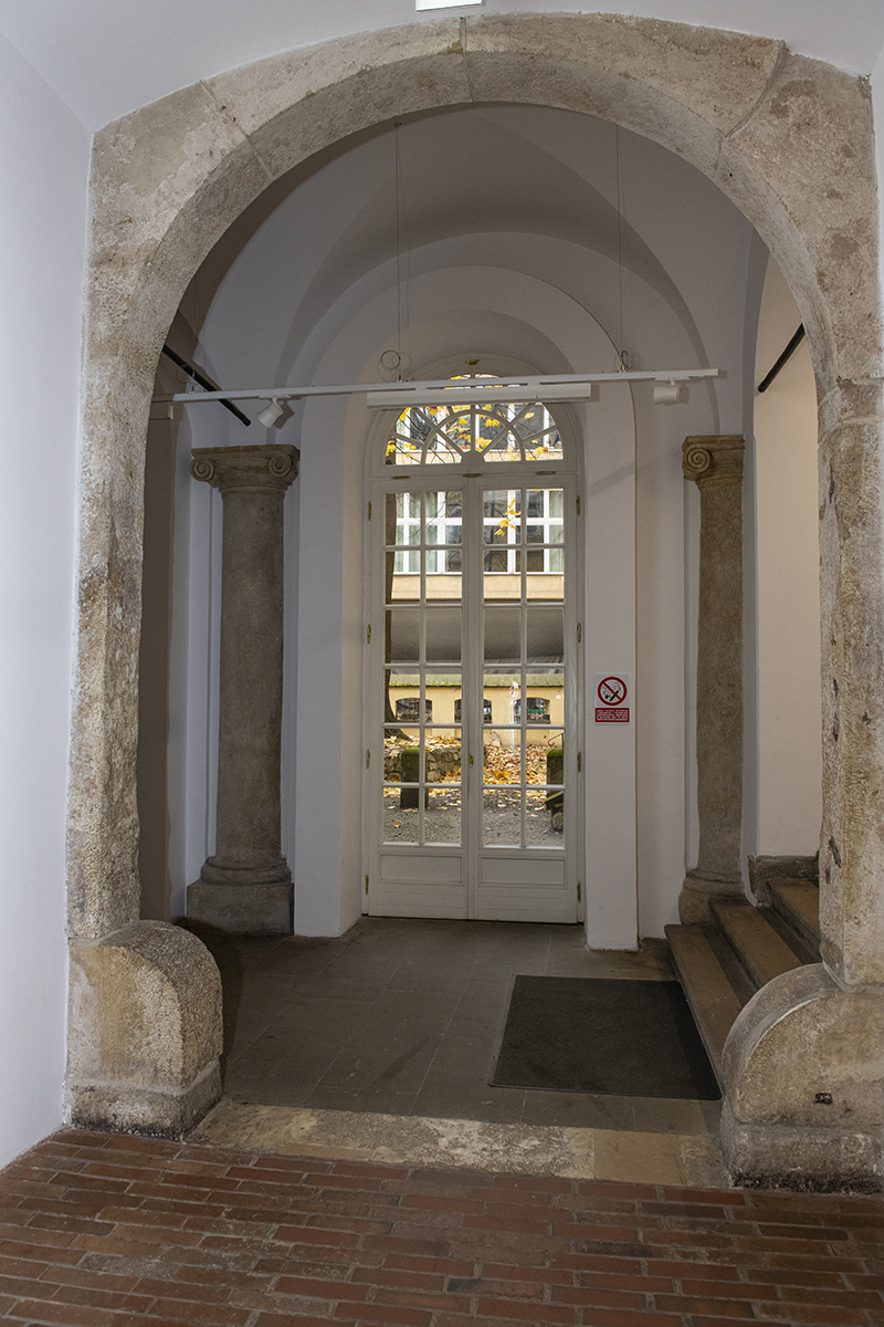 Sień, część zachodnia – portal dawnego wyjazdu na podworzec i kolumny arkadowego ganku, pochodzące z czasów budowy pałacu Samuela Maciejowskiego