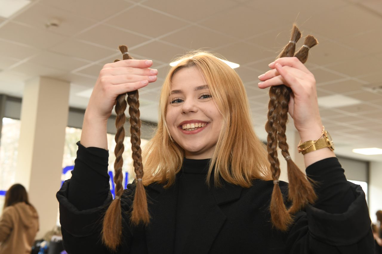 Organizatorka akcji Justyna Burz prezentuje obcięte włosy