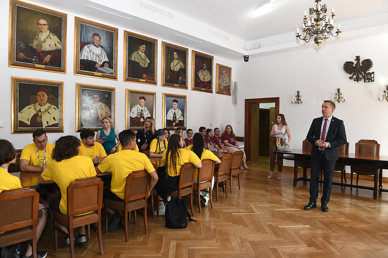 Uczestnicy Adapciaka na Politechnice Krakowskiej podczas spotkania z rektorem, który stoi i przemawia do studentów