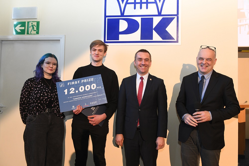Zdobywca I nagrody w towarzystwie rektora PK i dwóch innych osób pozuje do zdjęcia, w ręce trzyma symboliczny czek na 12 tys. zł