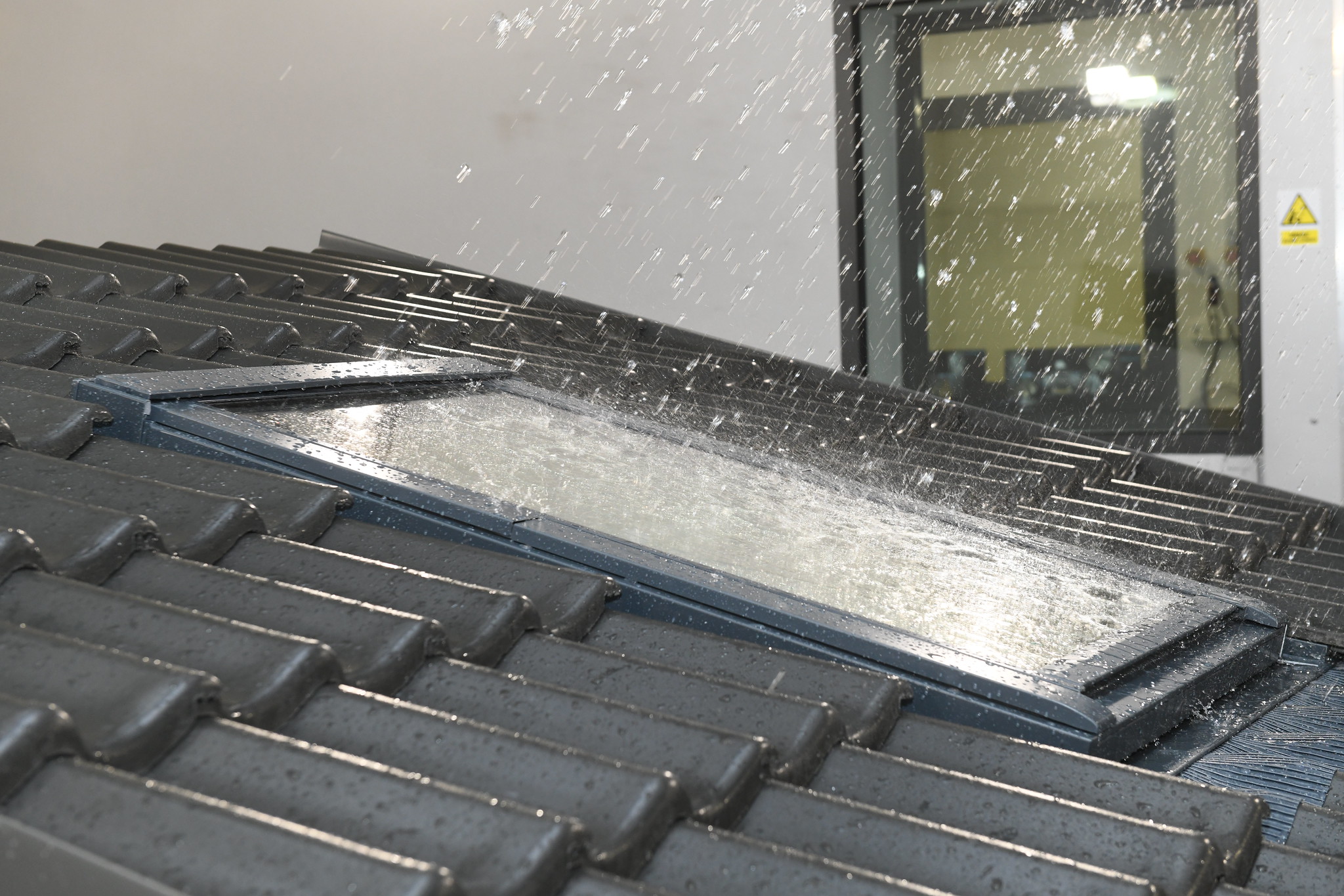Pomieszczenie laboratorium: okno dachowe poddawane testom z udziałem symulacji deszczu