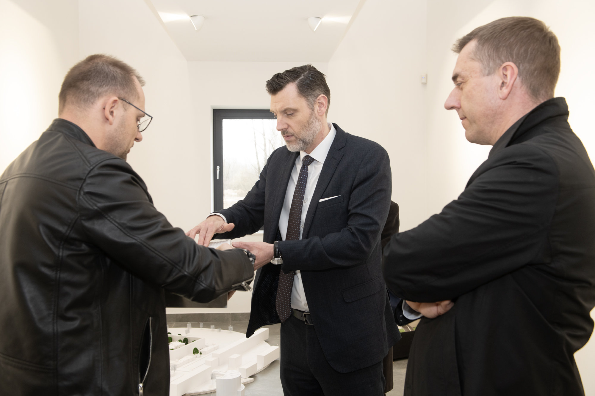 Dr Łukasz Flaga, konsul Francji i rektor PK oglądają rzecz, którą pokazuje dr Flaga