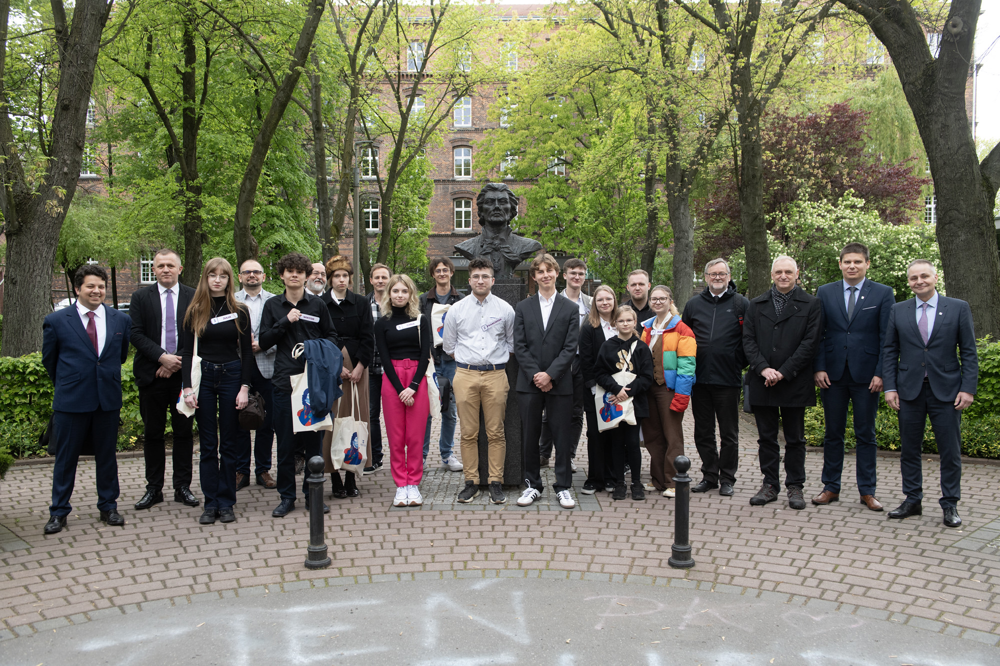 Finaliści, członkowie komisji konkursowej, nauczyciele i organizatorzy pozują do wspólnego zdjęcia przy popiersiu Tadeusza Kościuszki 